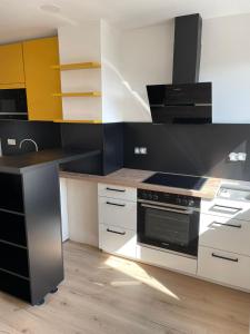 Joanna Apartment - Schwetzingen 3 في شفيتزينجين: مطبخ بدولاب بيضاء وفرن علوي موقد