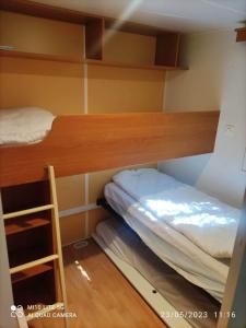 מיטה או מיטות בחדר ב-Camping les tilleuls du caminel Mobile home 97