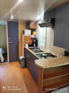 a kitchen with a stove and a counter top at Camping les tilleuls du caminel Mobile home 97 in Sarlat-la-Canéda