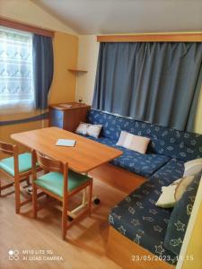 een woonkamer met een bank en een tafel bij Camping les tilleuls du caminel Mobile home 97 in Sarlat-la-Canéda