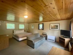 una camera da letto con un letto, un divano e una TV di Hanging Horn Lakeside Resort a Moose Lake