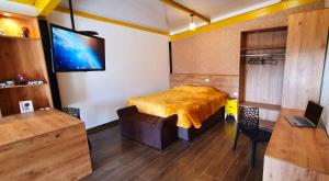 a bedroom with a bed and a flat screen tv at Golden Forest Pousada in Campos do Jordão