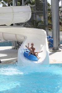 two children riding on a water slide at a resort at Anastasia Splash Residences in Protaras