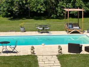 una piscina con mesa, sillas, mesa y sillas en Chateau Du Four De Vaux, en Varennes Vauzelles