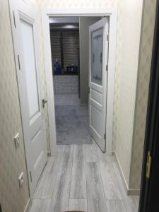 a hallway with two white doors and a tile floor at GREEN HAUS ONE in Tashkent