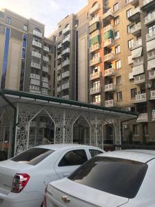 um carro branco estacionado em frente a alguns edifícios altos em GREEN HAUS ONE em Tashkent