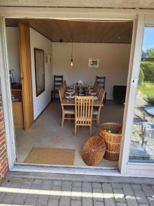un porche cubierto con mesa y sillas en 6 Room Holiday House, Private Garden, legohouse, legoland, lalandia, en Billund