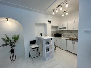 una cocina blanca con mesa y sillas. en Sweet Harmony, en Vračar (historical)