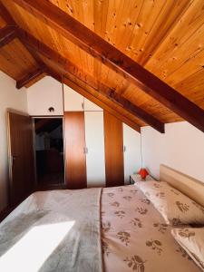 Schlafzimmer mit einem Bett mit Holzdecke in der Unterkunft Country House Bakicevo in Čilipi