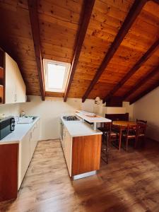 eine Küche mit Holzdecken, einem Tisch und einem Fenster in der Unterkunft Country House Bakicevo in Čilipi