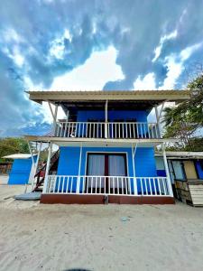 a blue house with a balcony on a beach at Khafii House in Kampong Pasir Panjang