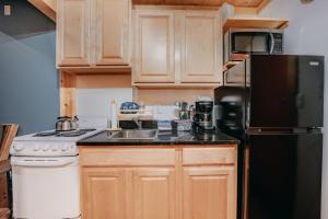 eine Küche mit Holzschränken und einem schwarzen Kühlschrank in der Unterkunft 18SLL - Newly Remodeled - Sleeps 4 - Fireplace - WithD condo in Glacier