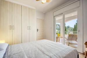 a bedroom with a bed and a sliding glass door at Sta Barbara 9 Canyelles Roses - Immo Barneda in Roses