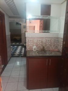 La salle de bains est pourvue d'un lavabo et de carrelage. dans l'établissement Riad Qariya siyahiya, à Marrakech