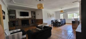 a living room with a fireplace and a dining room at HOSTAL SAN MARTIN DE MONTALBAN in San Martín de Montalbán