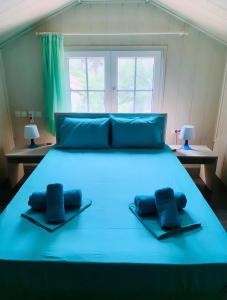 Una cama azul con dos almohadas encima. en Nadia's Beach House, en Pefkari