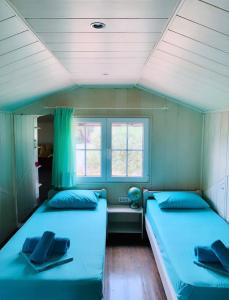 two beds in a room with two windows at Nadia's Beach House in Pefkari