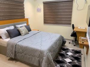 a bedroom with a bed and a desk and a television at Rehoboth Homes in Port Harcourt