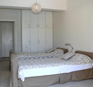 Un dormitorio con una cama con armarios blancos y una lámpara. en Ninas Place, 5min On Foot From The Beach, en Panormos Rethymno 31 fotos más