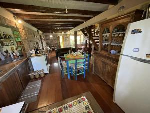 a kitchen and dining room with a table and a refrigerator at Pousada Casa Thede in Salvador do Sul
