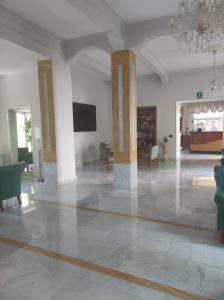 uma grande sala de estar com um lustre e uma mesa e cadeiras em Hotel Mazzocca em Caramanico Terme