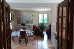 ein Esszimmer mit einem Tisch und Stühlen in einem Zimmer in der Unterkunft Villa de charme la Vinadière avec piscine privée et chauffée in Voutezac