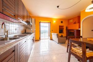 een keuken met gele muren en een eetkamer met een tafel bij Un Balcone sul Lago by Wonderful Italy in Montemezzo