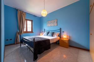 een slaapkamer met blauwe muren en een bed in een kamer bij Un Balcone sul Lago by Wonderful Italy in Montemezzo