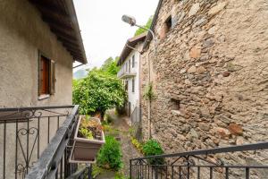 een steeg tussen twee gebouwen met een balkon bij Un Balcone sul Lago by Wonderful Italy in Montemezzo