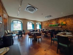 a dining room with tables and chairs and windows at Atrium Hotel Quinta De Pedras in Belém