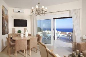 ein Esszimmer mit einem Tisch und Meerblick in der Unterkunft Luxury Villa Blanca With Sea View in Panormos