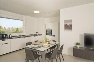 kuchnia i jadalnia ze stołem i krzesłami w obiekcie Katya Resort Apartments by Wonderful Italy w mieście Desenzano del Garda