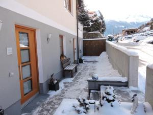 een met sneeuw bedekte loopbrug naar een gebouw met een bank bij Apartment Gschwandtner Haus Stoareich in Bad Gastein