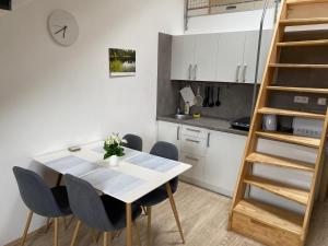 uma cozinha com uma mesa e cadeiras e uma escada em Mezonetový apartmán Isabela em Loučná nad Desnou