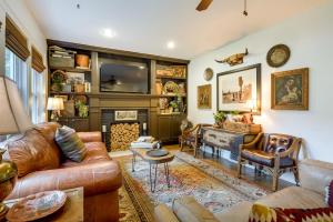 a living room with leather furniture and a piano at Whimsical Cottage Near Springfield Art Museum! in Springfield