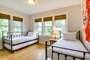 two beds in a room with windows at Whimsical Cottage Near Springfield Art Museum! in Springfield