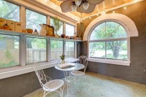 a room with a table and chairs and windows at Whimsical Cottage Near Springfield Art Museum! in Springfield