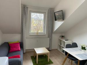 uma sala de estar com um sofá e uma janela em Mezonetový apartmán Isabela em Loučná nad Desnou