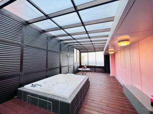 un ampio bagno con una grande vasca in una stanza di Esperanza Resort Atami-エスペランサリゾート熱海 ad Atami