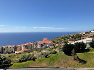 a group of buildings on a hill next to the ocean at Moniz Apartment in Caniço