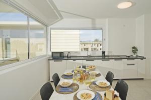 uma cozinha com uma mesa com pratos de comida em Katya Resort Apartments by Wonderful Italy em Desenzano del Garda