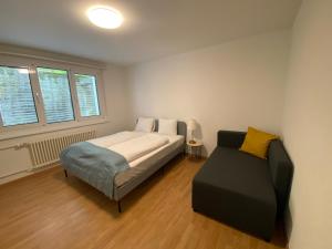 a bedroom with a bed and a couch in it at Galaxy Apartments Lucerne in Lucerne