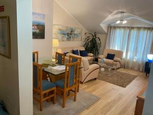 un soggiorno con tavolo, sedie e divano di Moniz Apartment a Caniço