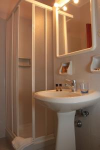 a bathroom with a sink and a mirror and a shower at Hotel Plaza in Taranto