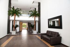 un pasillo con palmeras y un sofá de cuero en Apartment in countryside with hotel services, en Rionegro