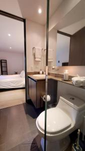 1 cama y baño con aseo y lavamanos. en Apartment in countryside with hotel services, en Rionegro