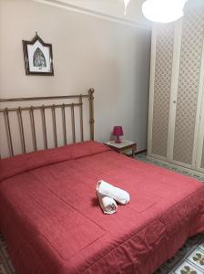 łóżko z czerwoną narzutą i dwoma ręcznikami w obiekcie Signorile appartamento in condominio Rallo w mieście Palermo