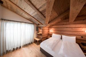 a bedroom with a white bed and a wooden ceiling at Rifugio Salei in Canazei +62 photos