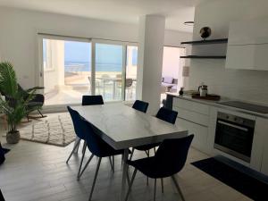 a kitchen with a table and chairs with a view of the ocean at Sapphire Penthouse in Tropea