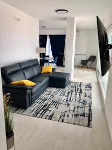 a living room with a black couch and a rug at Sapphire Penthouse in Tropea
